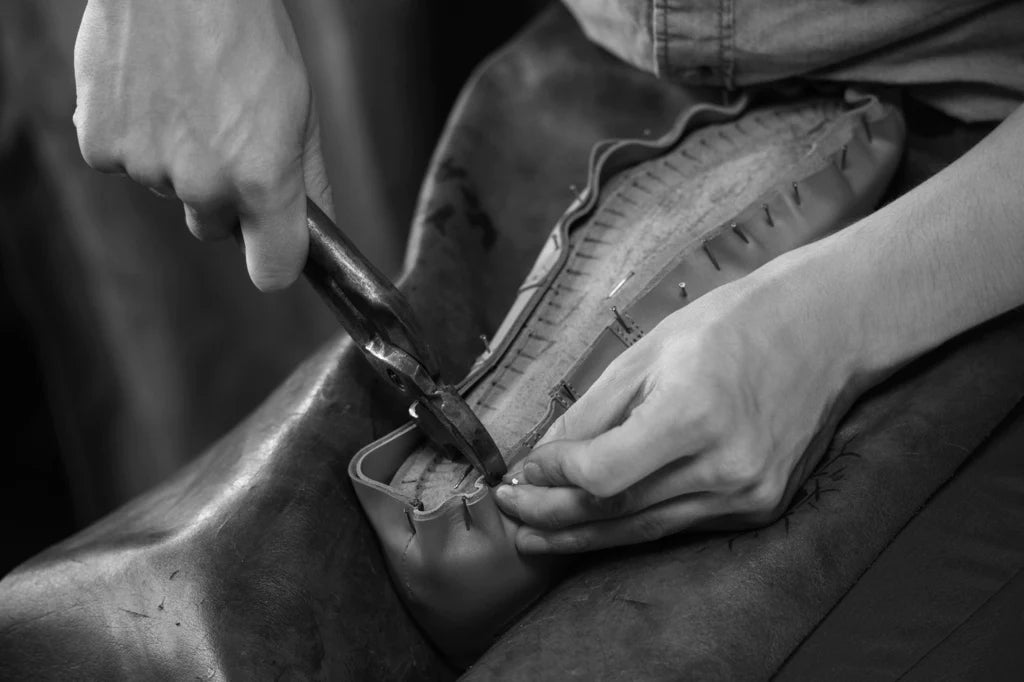 Bondeno shoemaker lasting leather over a wooden shoe last