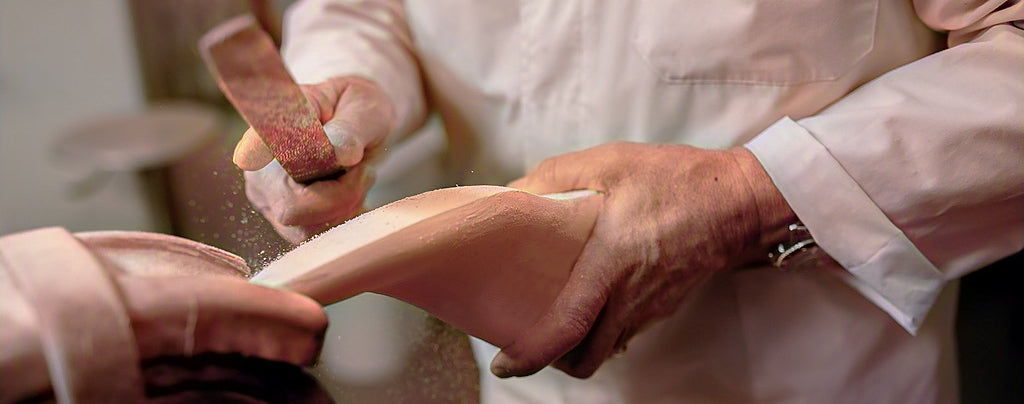 Last maker shaping a wooden shoe last for a bespoke pair