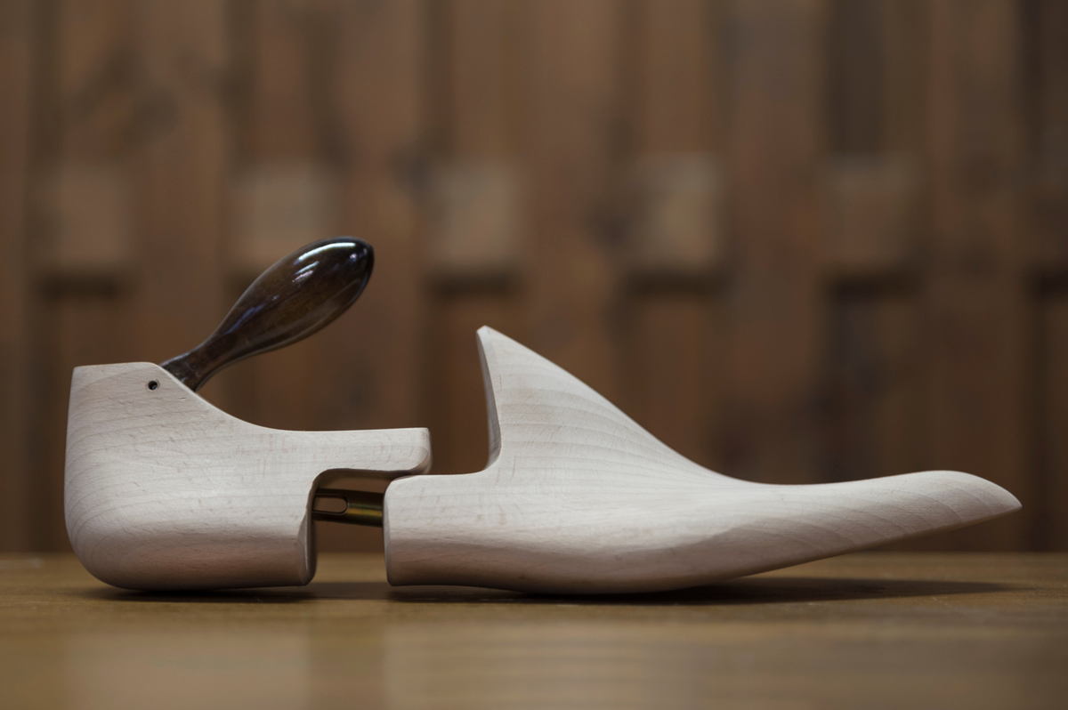 Bondeno bespoke shoe stretcher, a pale beechwood form with a dark wooden handle, side view
